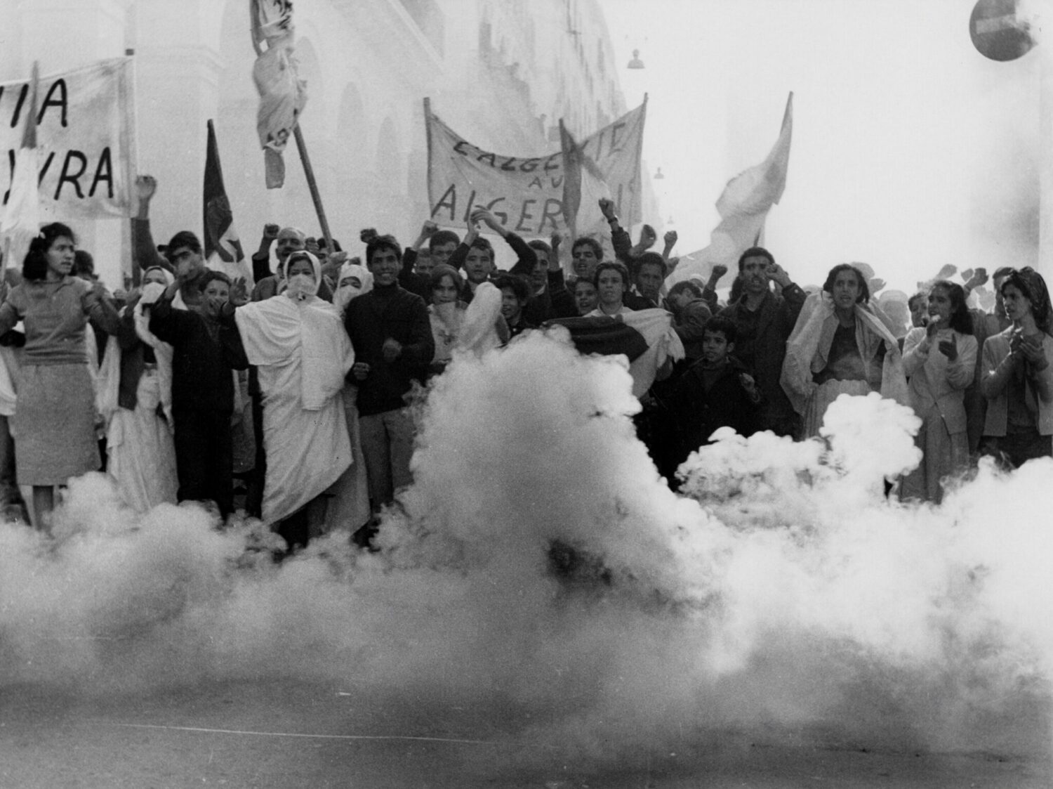 Crowd of Algerian people gathered with protest signs circa 1966.